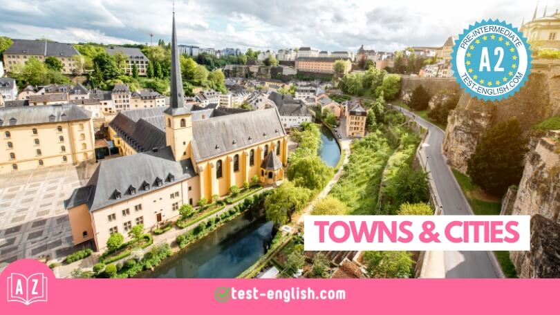 Scenic view of a historic town with a church, river, and lush greenery, representing the A2 English Vocabulary lesson on Towns and Cities.